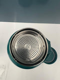 Teal mug with metal filter on a white surface