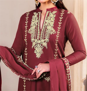 Maroon traditional outfit with gold embroidery on a neutral background